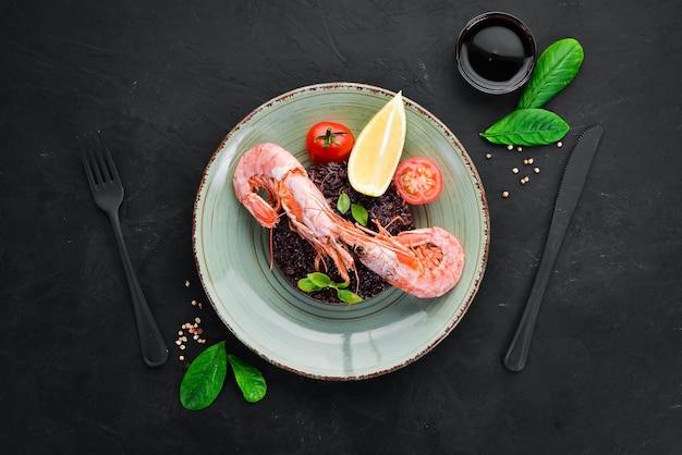 Arroz negro con gambas y verduras En el fondo antiguo Vista superior Espacio libre para el texto