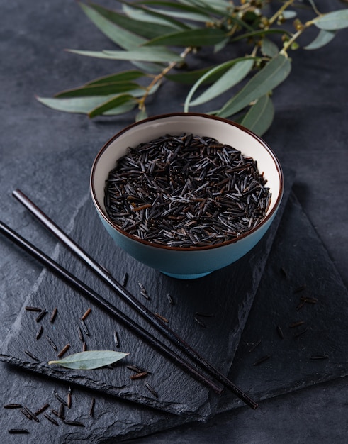 Arroz negro en un tazón azul en un tablero