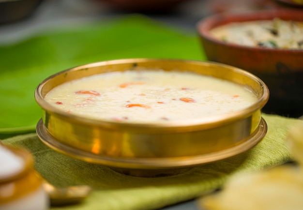 Arroz paalada payasam dispuesto en un recipiente de latón con guarniciones de fiesta de Kerala en el enfoque backgroundselective