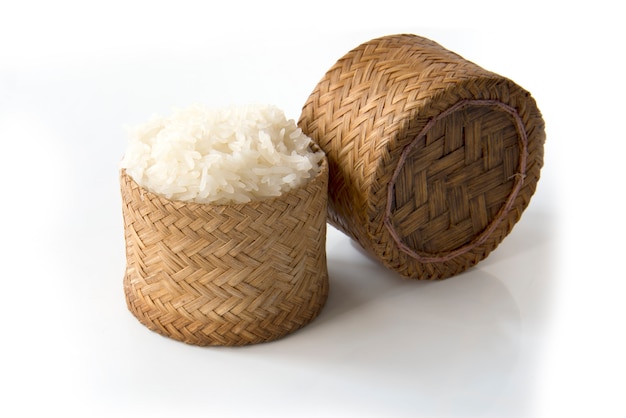 Arroz pegajoso, arroz pegajoso tailandés en una caja de madera de bambú del viejo estilo aislada en el fondo blanco
