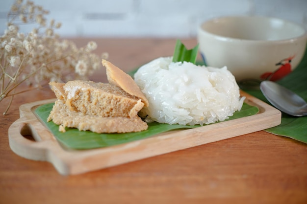 Arroz pegajoso com sobremesas tailandesas de creme de ovo em uma mesa de madeira