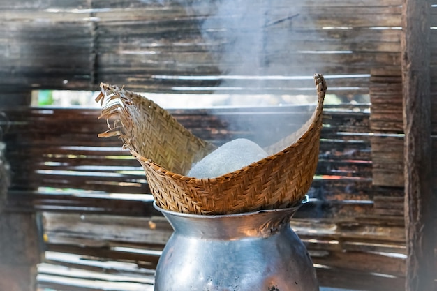 Arroz pegajoso é cozido no vapor em um vapor de bambu, pela manhã.