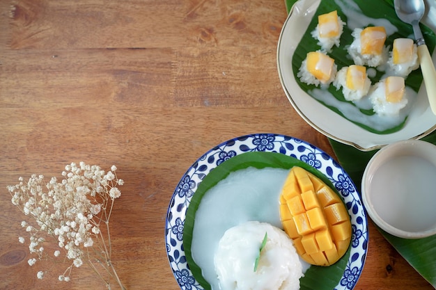 Arroz pegajoso con mango maduro en leche de coco Auténticos postres tailandeses en una mesa de madera