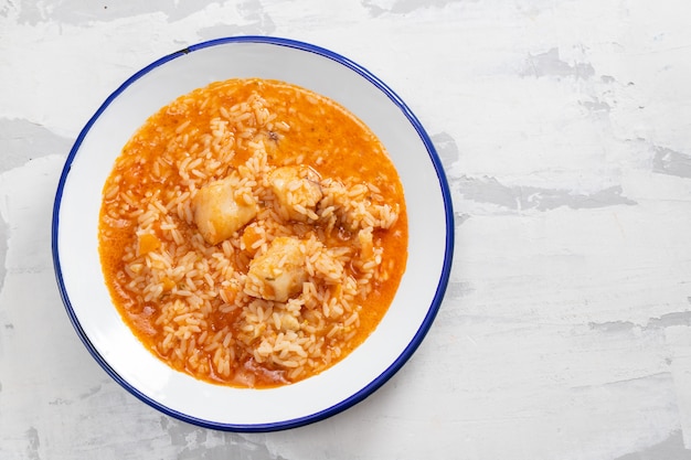 Arroz con pescado y tomate en un plato