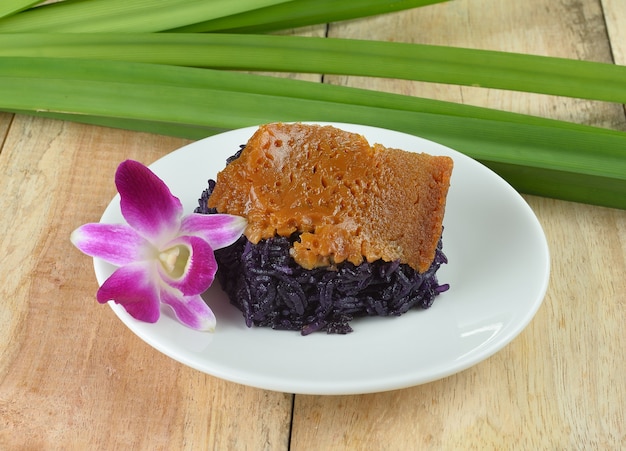 Arroz preto com creme cozido no vapor na mesa de madeira