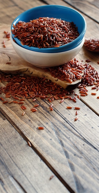 Arroz rojo crudo en un recipiente sobre la mesa de madera