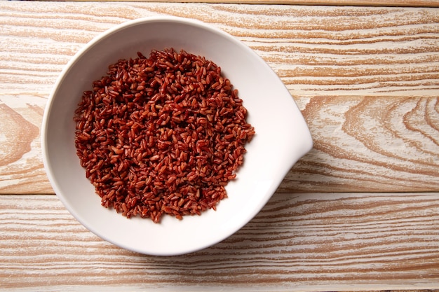 Arroz salvaje rojo en un plato blanco sobre madera