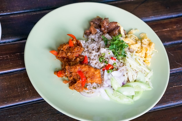 Foto arroz sazonado con pasta de camarones, y curry de pescado frito.