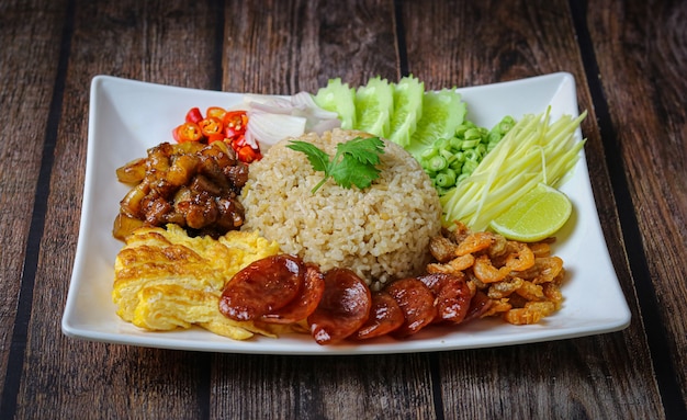 Foto arroz sazonado con pasta de camarones o mezcla de arroz rodaja de cebolla morada, frijol, mango, huevo frito