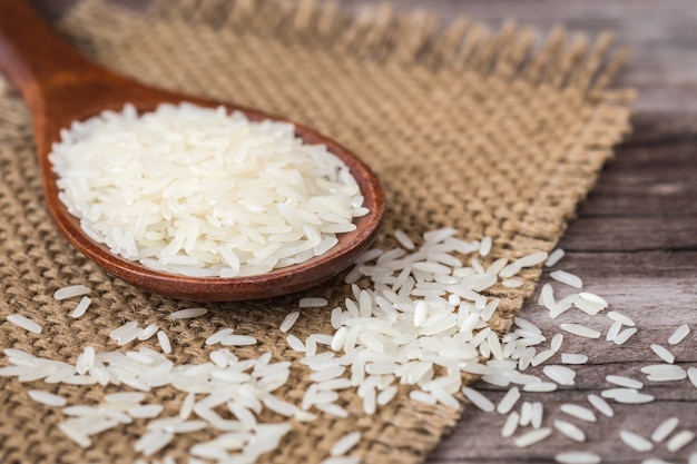 Arroz tailandés blanco del jazmín en fondo de madera del tablón