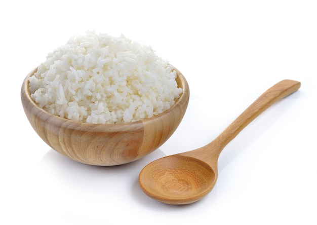 Arroz en un tazón de madera en la pared blanca