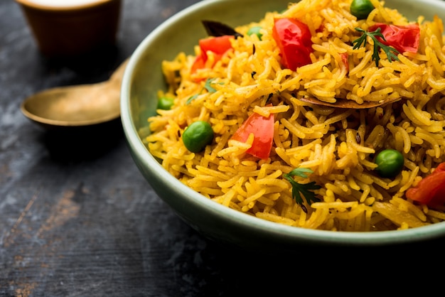 Arroz con tomate, también conocido como Tamatar Pilaf o pulav elaborado con arroz basmati, servido en un tazón. enfoque selectivo