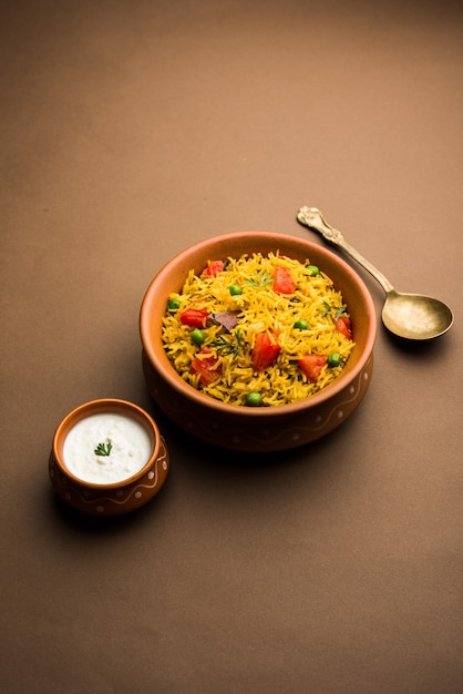 Arroz con tomate, también conocido como Tamatar Pilaf o pulav elaborado con arroz basmati, servido en un tazón. enfoque selectivo