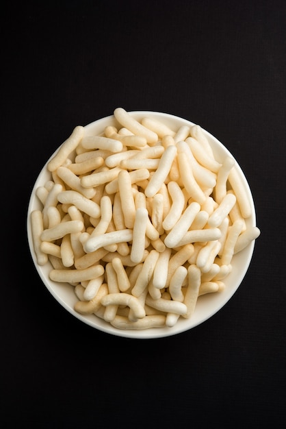 Arroz tufado, trigo ou lanche de milho, também conhecido como Fryums, servido sobre um fundo sombrio
