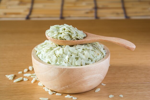 Arroz verde em uma xícara de madeira e colher