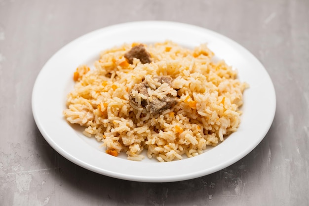 Arroz con verduras y carne en plato blanco.