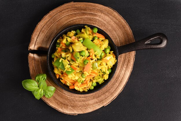 Arroz con verduras y condimento amarillo en una sartén