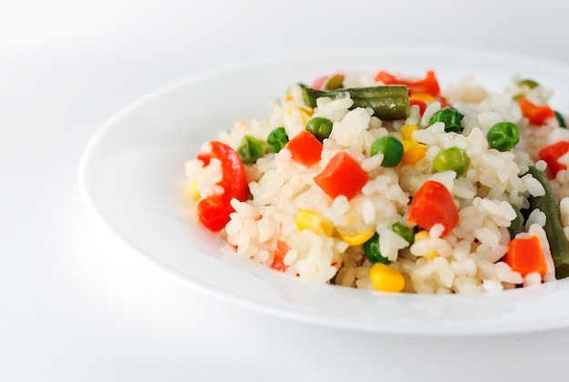 Arroz con verduras sobre fondo blanco.