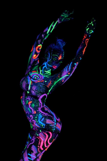 Foto arte de cuerpo de mujer de arte en el cuerpo bailando en luz ultravioleta. dibujos abstractos brillantes en el color neón del cuerpo de la mujer. cabello y cara teñidos