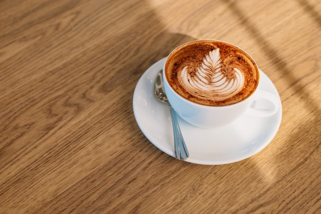 Arte de café com leite na mesa de madeira