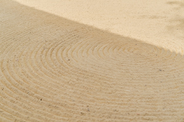 Foto arte de padrão de onda de curva contínua no fundo de areia.