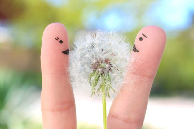 Arte de los dedos de la feliz pareja. El hombre está dando flores a la mujer.