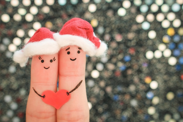 El arte de los dedos de la pareja celebra la Navidad con sombreros de año nuevo