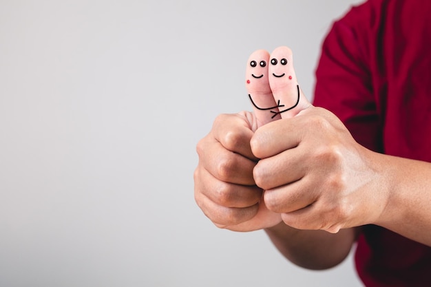 Arte do amor nos dedos, abraçando os polegares das mãos, conectado ao conceito de dia dos namorados com espaço de cópia