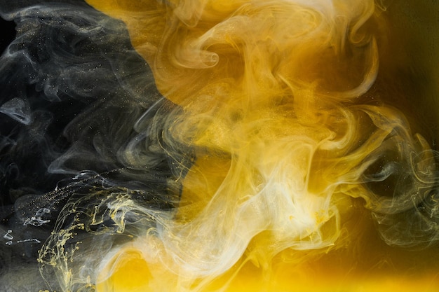 Arte fluida líquida Fundo abstrato Preto amarelo dançando tintas acrílicas espaço subaquático fumaça oceano