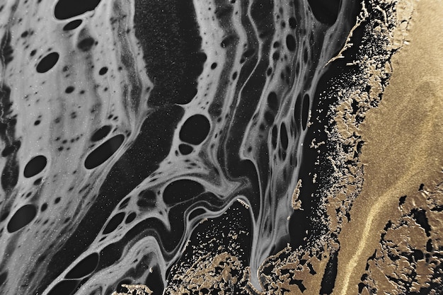 Arte fluida. ouro metálico e ondas abstratas cinza sobre fundo preto. fundo ou textura de efeito de mármore