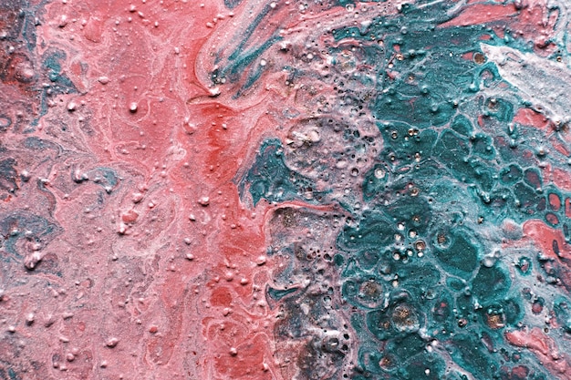 Arte fluido Cráteres de trazos en relieve y gotas de pintura rosa y verde Fondo o textura de efecto mármol