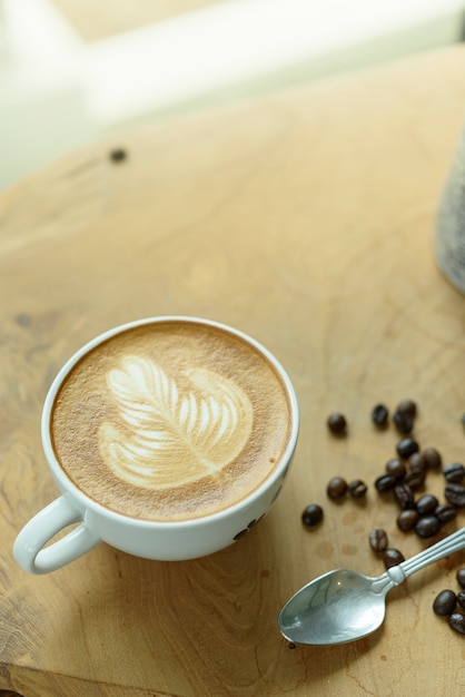 Arte del latte de café en la mesa de madera.