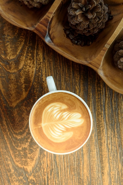 Arte del latte de café en la mesa de madera.