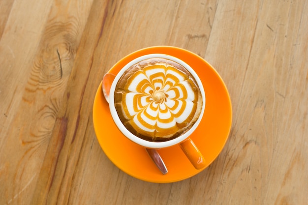 Un arte de Latte Coffee en el escritorio de madera.