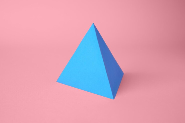 Foto arte de origami pirámide de papel sobre fondo rosa