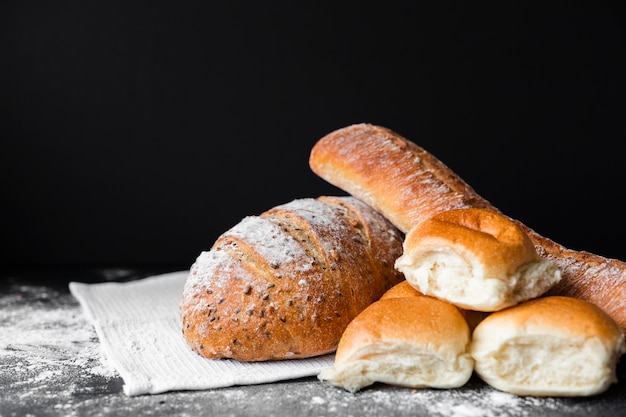 Arten von frischem Brot mit Mehl auf Tuch