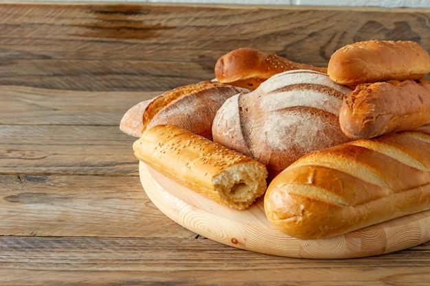 Arten von hausgemachtem Brot auf dem rustikalen Holztisch. Hausgemachtes gebackenes Gebäck.