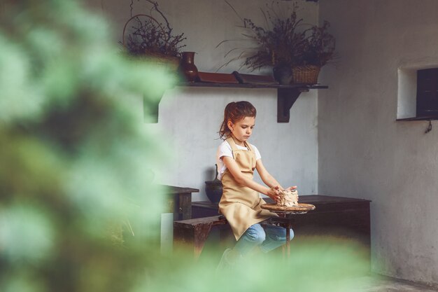 Artesana encantadora niña disfrutando el arte de la cerámica y el proceso de producción