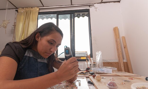 Foto artesana latina trabajando con una máquina