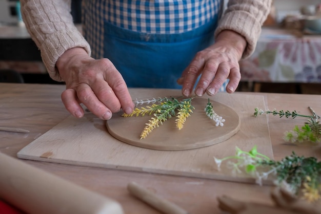 Artesana senior creando cerámica hecha a mano en un estudio de alfarería