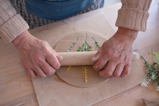 Artesana senior creando cerámica hecha a mano en un estudio de alfarería