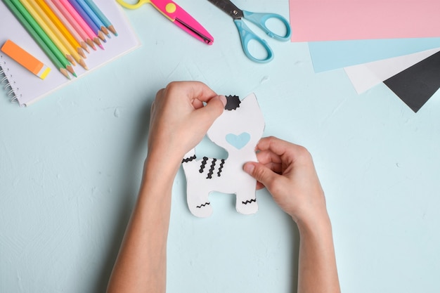 Artesanato com mãos de criança em papel colorido. Feito à mão. O tigre branco. Gato. Uma master class sobre como fazer um tigre.