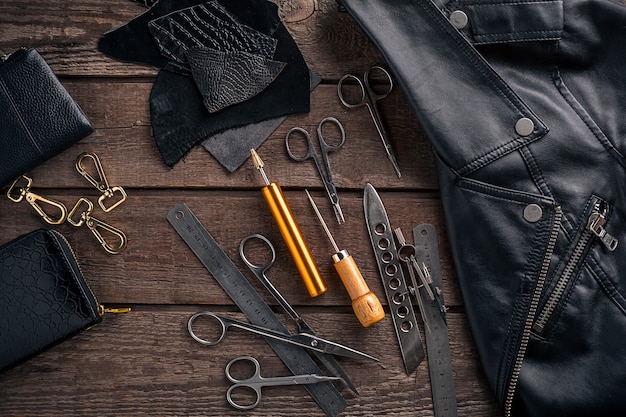 Artesanía en cuero o trabajo en cuero, herramientas de trabajo en cuero y recortar piezas de cuero en el escritorio de trabajo