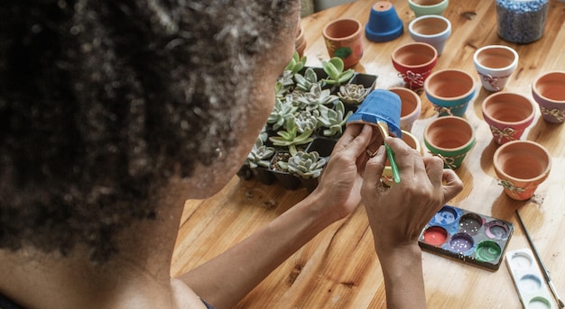 Artesanía latinoamericana, pintar y decorar vasijas de barro para cultivar plantas suculentas