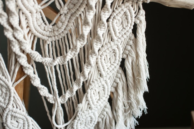 La artesanía de una pared de macrame colgada con manos artísticas