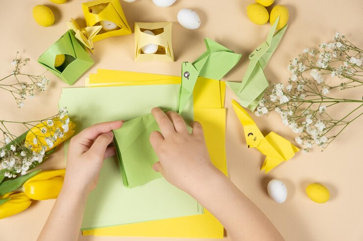 Foto artesanías de papel para origami de pascua haciendo figuritas de conejitos de pascua