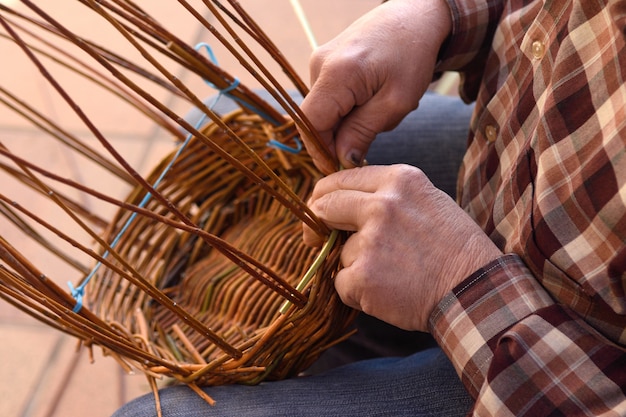 Artesano haciendo canasta de mimbre.