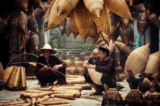 Artesano haciendo trampa para peces de bambú en la antigua aldea, Hung Yen, Vietnam