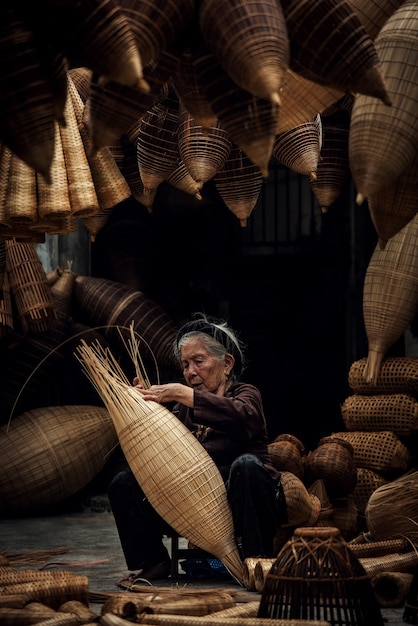 Artesano haciendo trampa para peces de bambú en la antigua aldea, Hung Yen, Vietnam