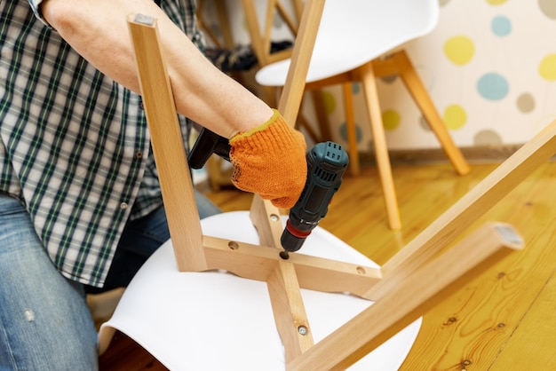 Artesano que recoge con herramientas y ensambla muebles con destornillador